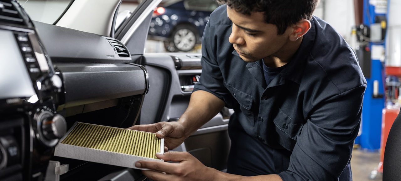 Auto mechanic replacing a cabin air filter